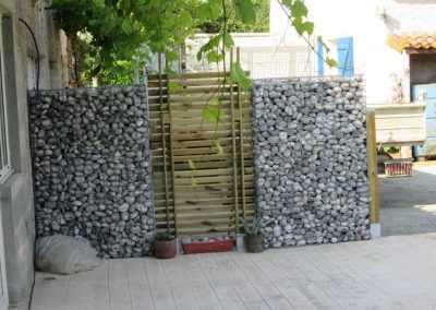 Clôture de gabion avec galets et claustra bois